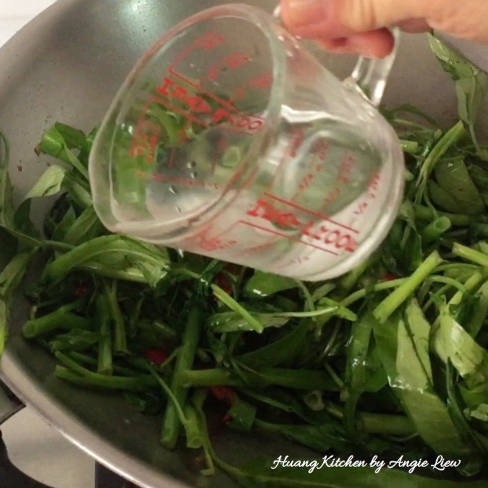 Then add in a splash of hot water and continue to stir fry for another 30 seconds, making sure the greens is well mix with the seasonings.