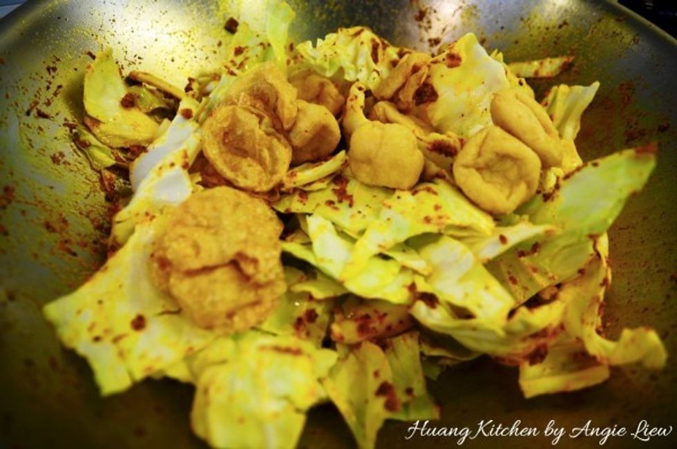 Then add in cabbage, beancurd puffs and gluten balls. Fry to combine everything together.