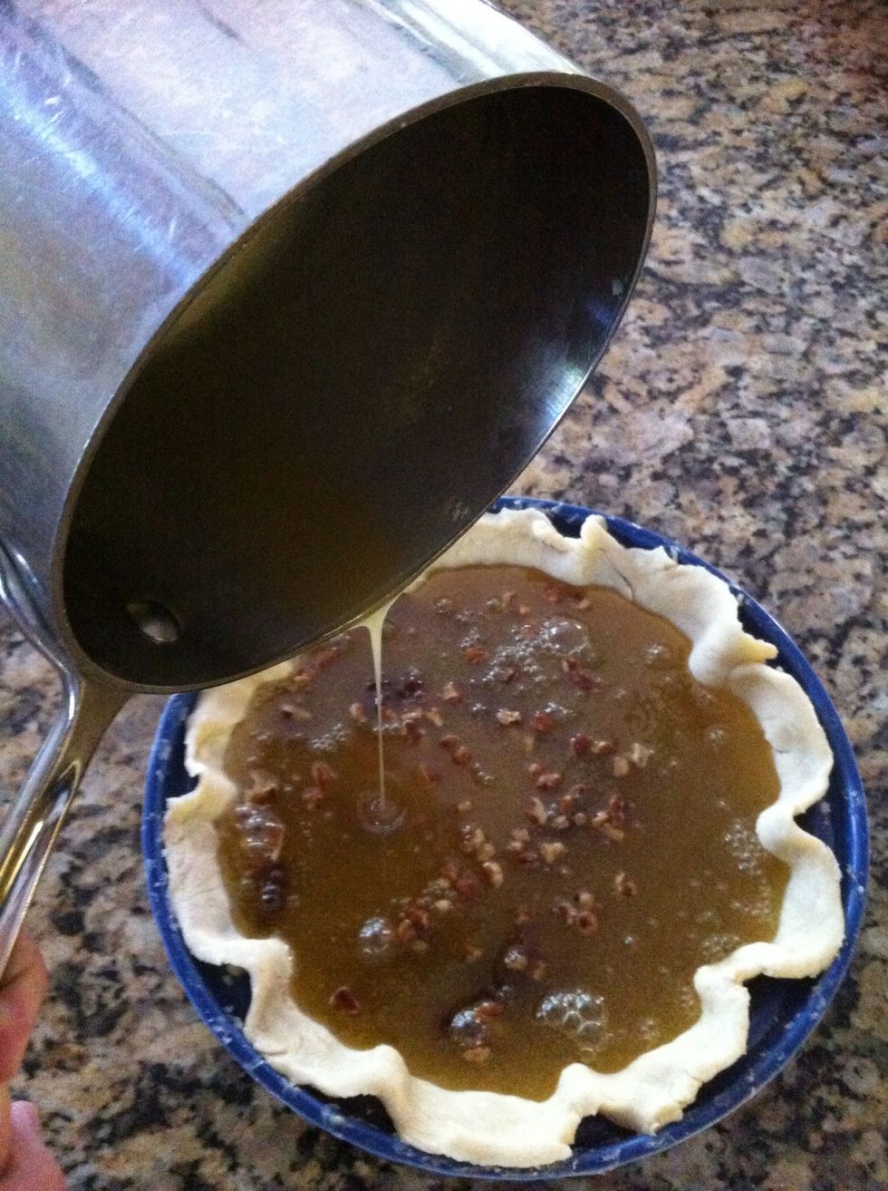 Then add one egg at a time into your filling. Stir quickly bc the filling is hot. Once done, Pour into pie shell, over the nuts and chocolate