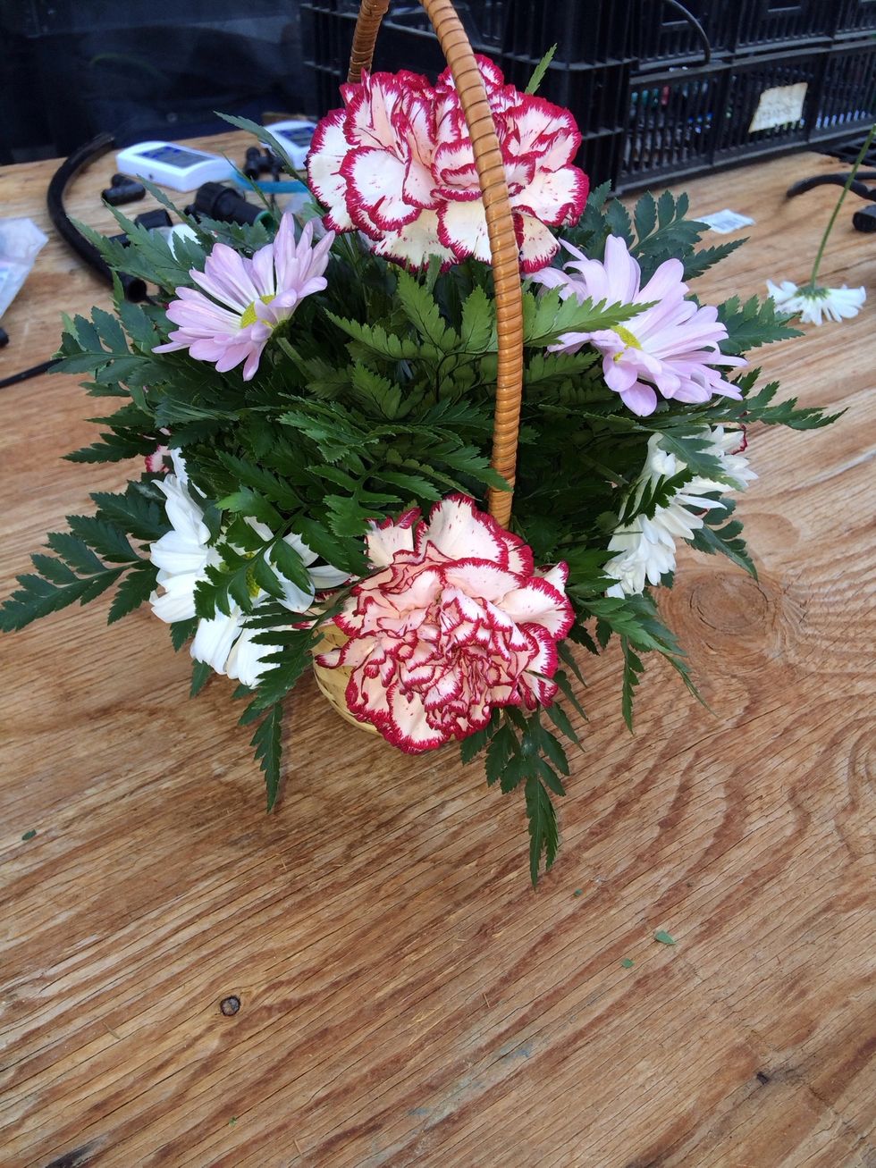 Then add the 3 white daisies just below the purple daisies and towards the carnations so your daisies create an open space.