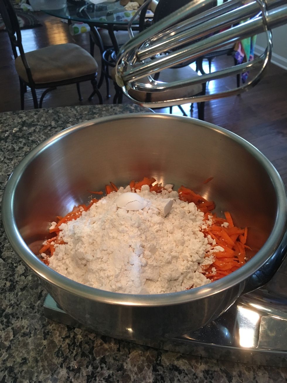 Then, add the baking powder into the mixing bowl with the carrots and all-purpose flour.