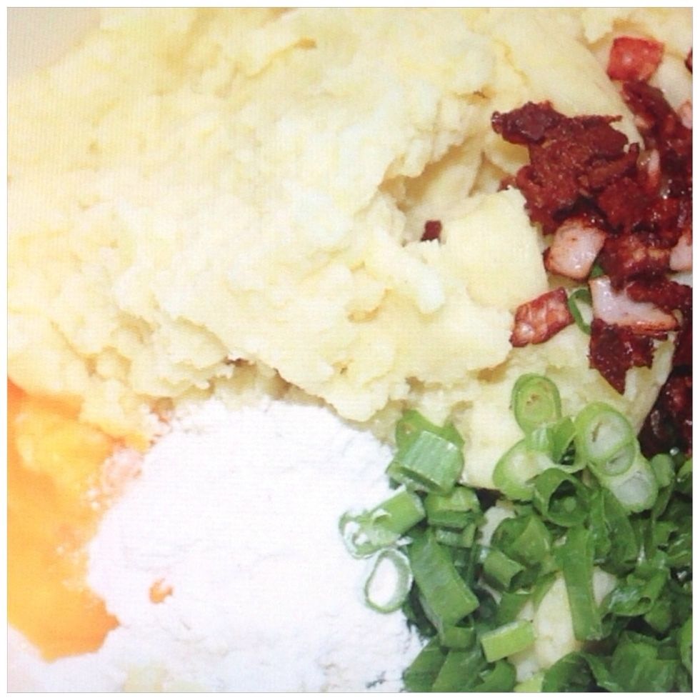 Then, add the spring onion, bacon, egg yolk and 1/4 cup of flour and mix thoroughly