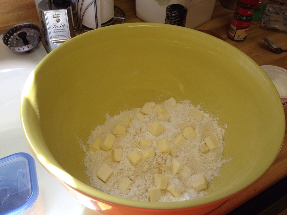 Then add your baking powder garlic and salt. Stir. Drop in butter. Use a pastry cutter or your fingers to incorporate the butter.