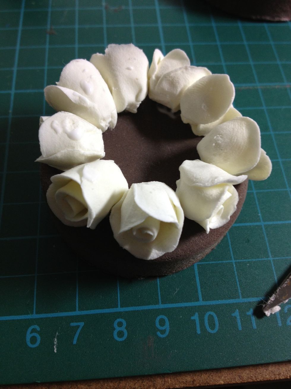 Then, attach the roses along the side. Remember to allow the roses to dry a bit (around 1 hour) in order to avoid damage when work on.