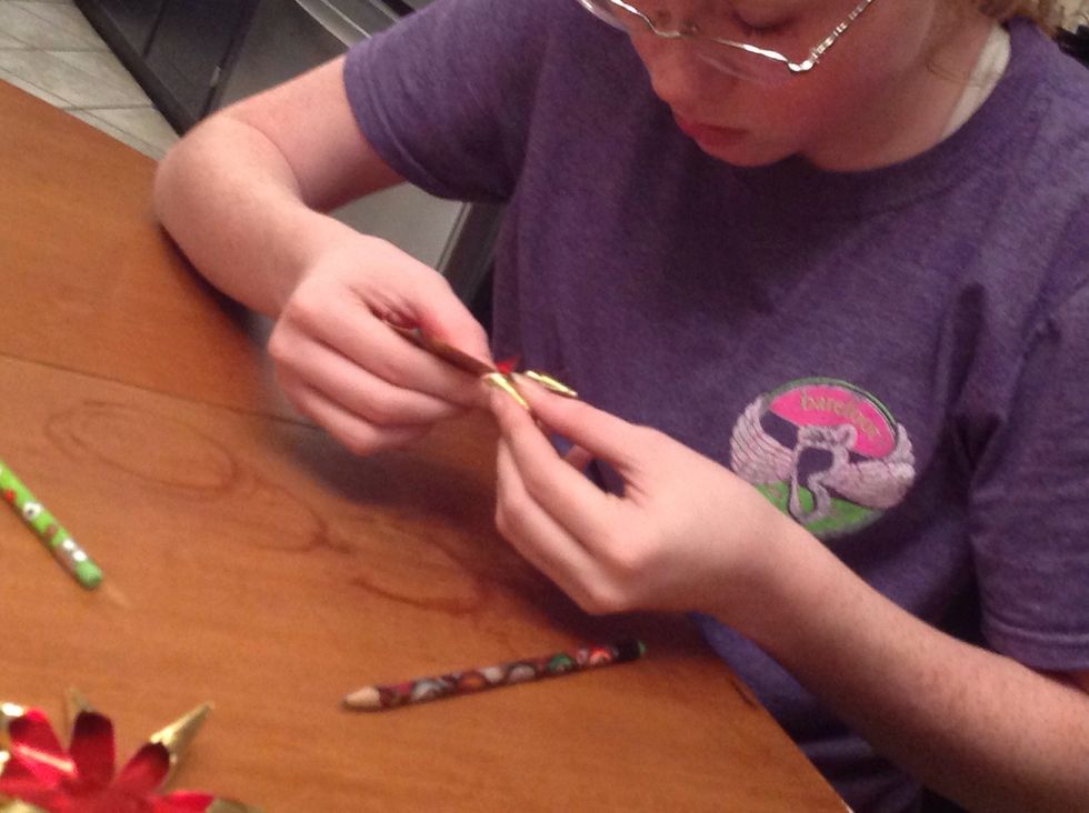 Then bend the other side of the same piece over the roll that was created. Try to make a super tight point. It took my teenager a few tries, but she nailed it and then taught the 9 year old.