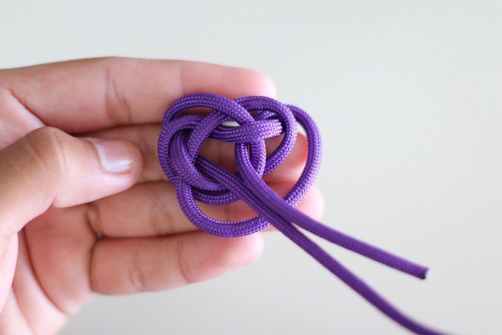 Then bring it through the center hole like what you did with the previous cord. Like so in the picture above.