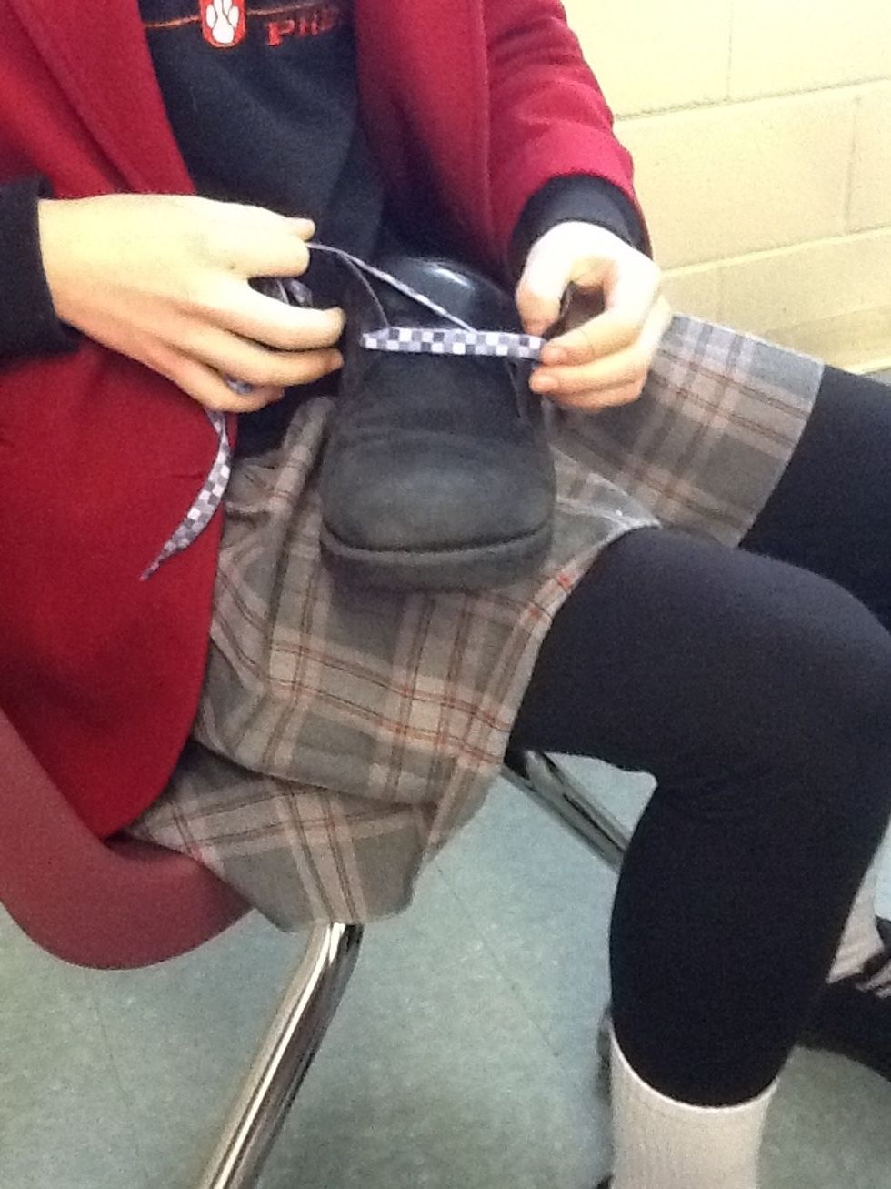 Then bring the shoelace around to the opposite side and pull it through from the inside