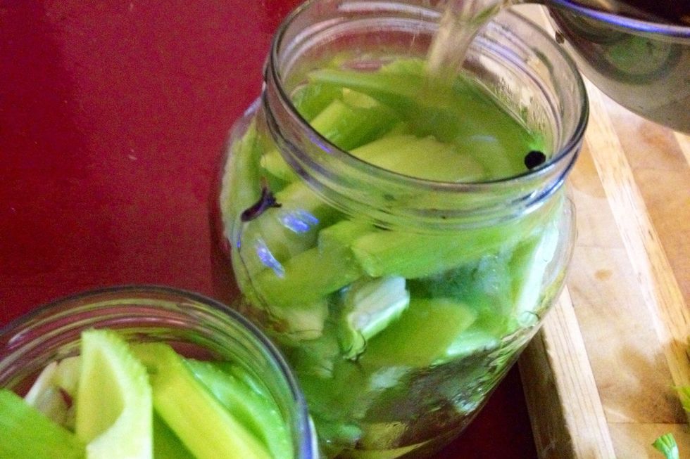 Then carefully pour hot liquid into celery-filled jar. Wait a while \u2013 there'll be spaces created in jar due to the hot liquid partially cooking the celery, shrinking it somewhat and resettling it.