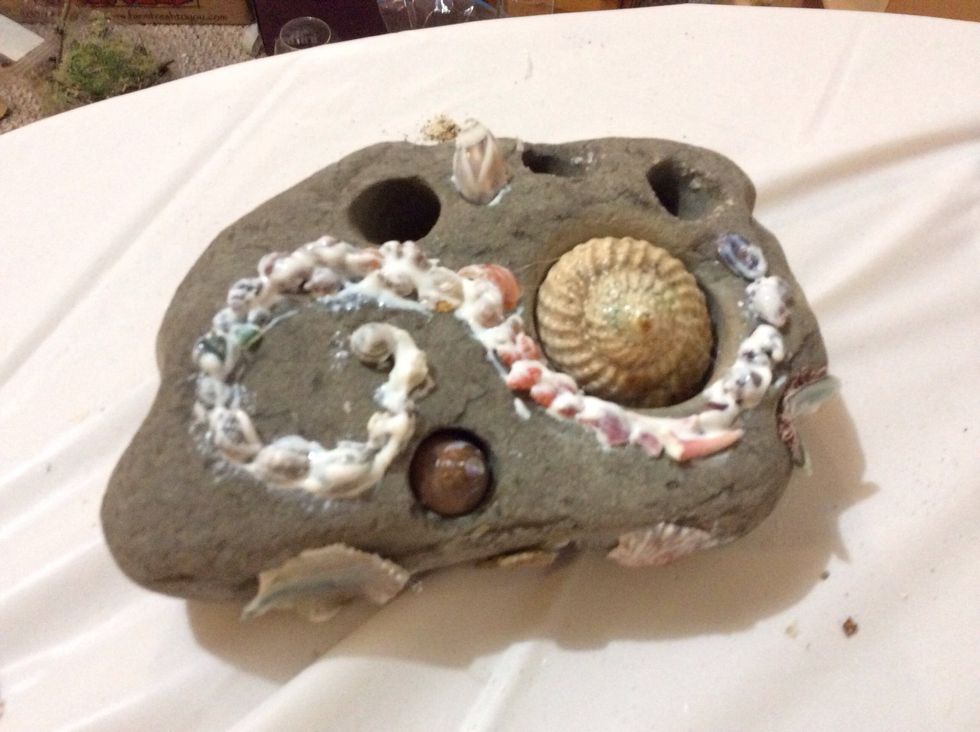 Then coat all shells with a second layer of modge podge glue to solidify hold and add shine. Hot glue larger shells to rock and then coat them with decoupage too.