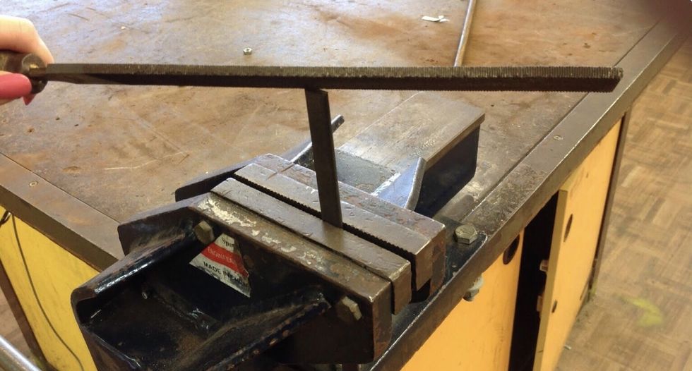 Then cut off 7cm of your flat bar from the scroll for your leg, file both ends. Btw in the middle of the 7cm cut off your need to drill a hole to then be pop riveted into the three components of metal