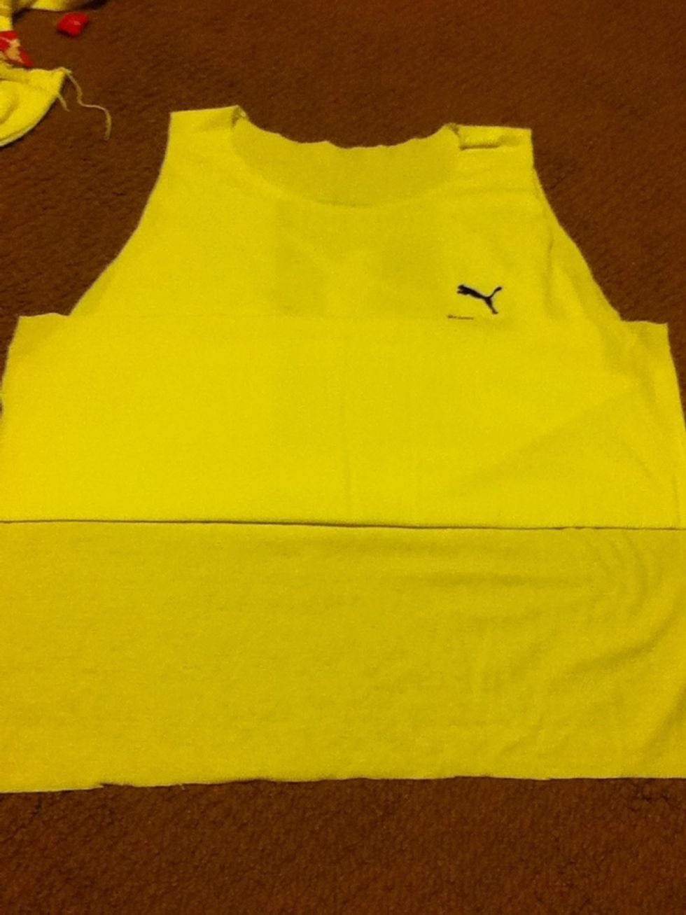 Then cut the sides so you can fold the shirt like this. After that cut off the excess material on the back which you see in this picture