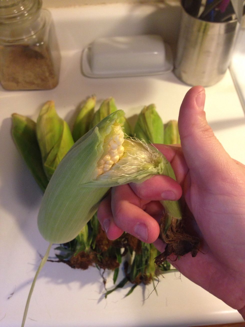 Then do basically the same thing to the top and pull the rest of the leaves off. This method helps pull the silk with it. You want to get as much of the silk off as possible.