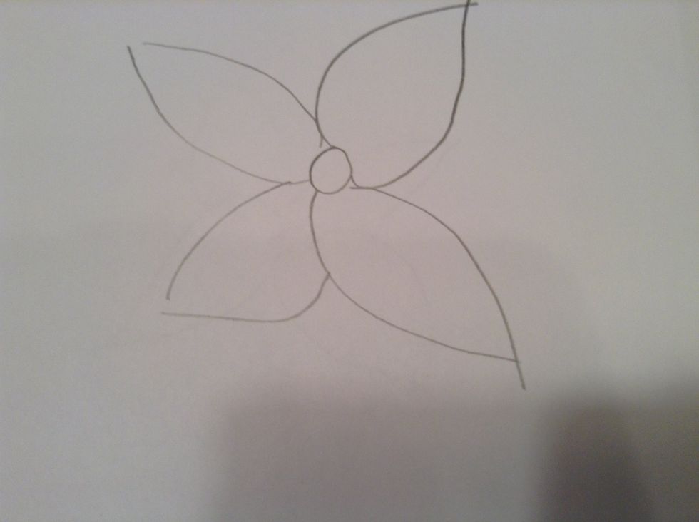 Then draw four medium sized ovals with pointy ends in the front around the medium sized circle in the middle. Continue drawing smaller or bigger ovals in between the last.