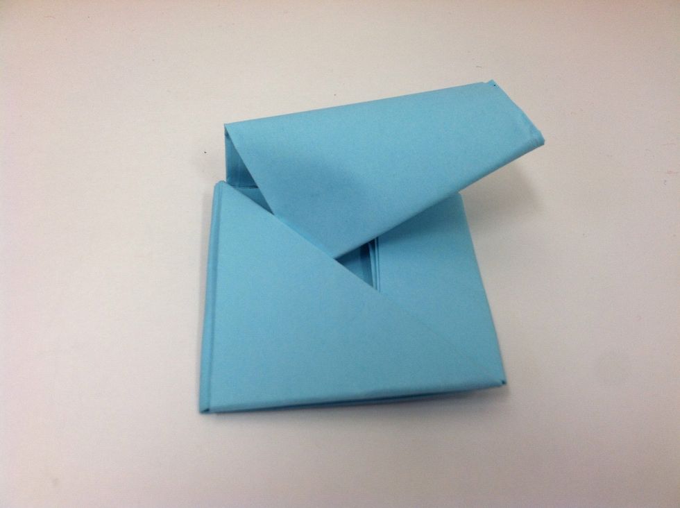 Then fold along the line you drew to mark the top of the square, and tuck it into the triangular pocket also.