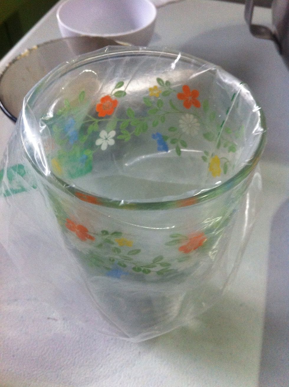 Then fold the sides of the plastic pastry bag around the glass mouth. See the photo.