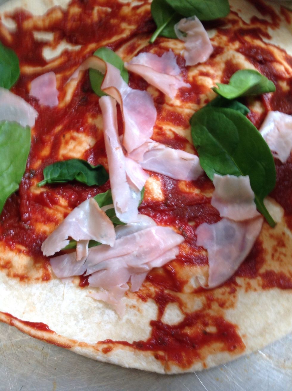 Then get some ham and rip it up and put it on the pizza like this