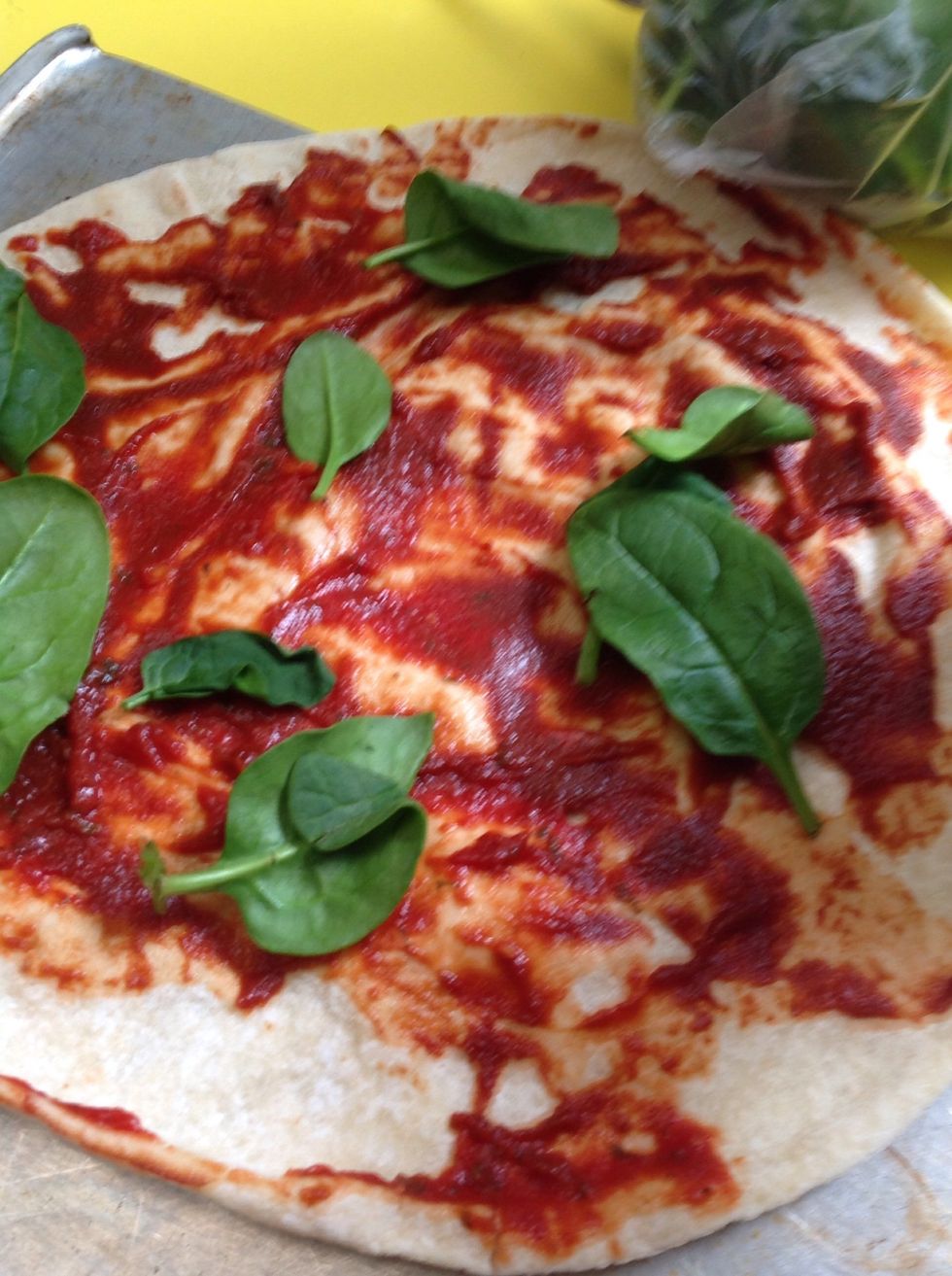 Then grab some spinach leaves and sprinkle the leaves over the pizza