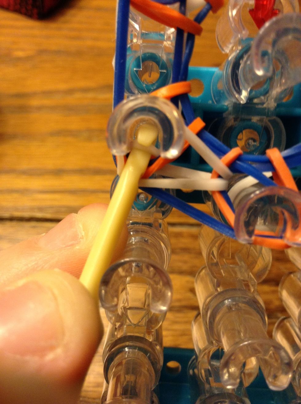 Then grab the top white band and loop to the one above. Continue to the top.