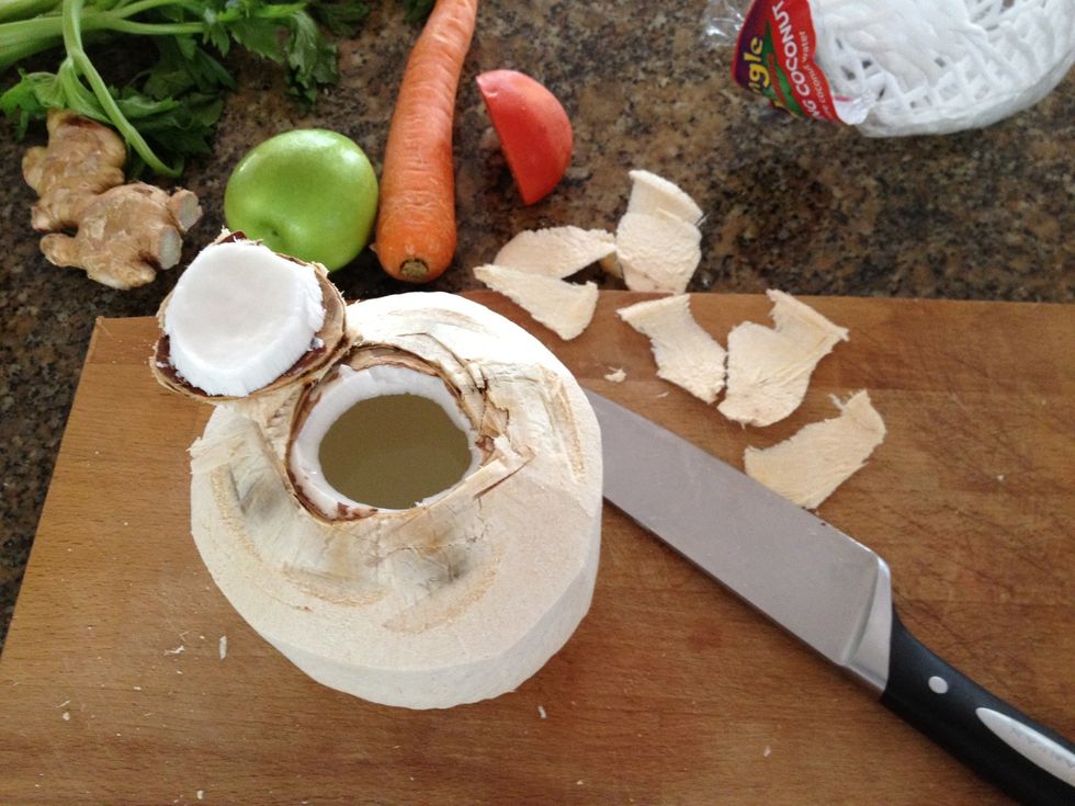 Then hit it reasonably hard with your knife making a square on top of the coconut. Once the layer cracks, slide the knife in, lift and open.