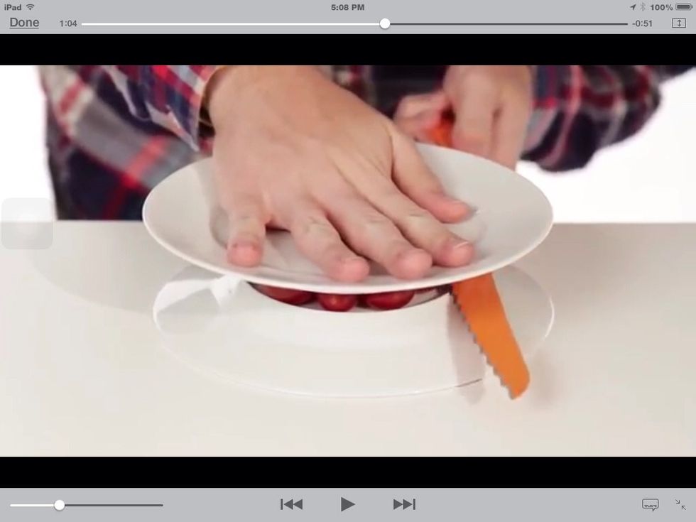Then, hold the top plate down, and use a knife to cute the tomatoes.