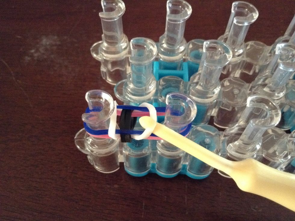 Then hook the bottom rubber band on top of the other two rubber bands