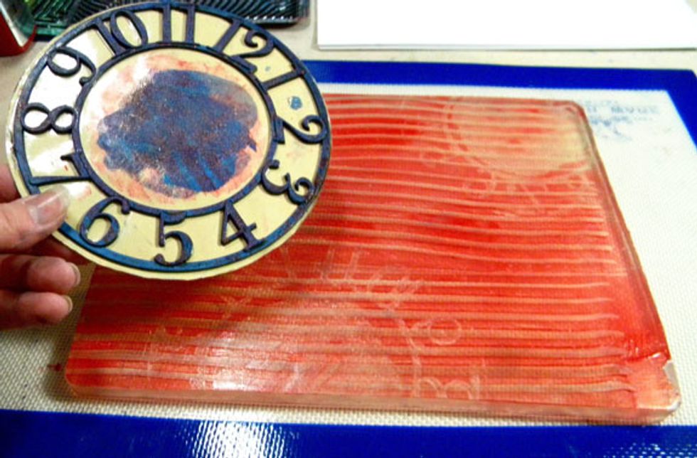 Then I pressed this plastic clock sticker into the lined pattern on the plate.  Look around your house for different things to use on the Gelli Plate. Bubble wrap, string, combs, leaves, lids.....