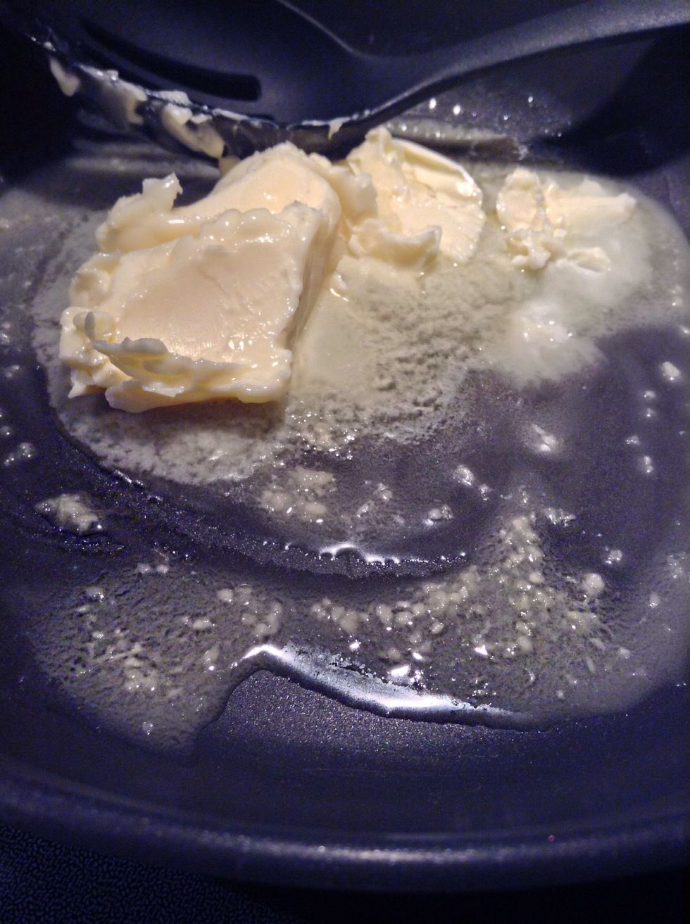 Then in a medium sauce pan over medium heat place butter and garlic into pan. Allow to cook for two minutes or until butter is fully melted.
