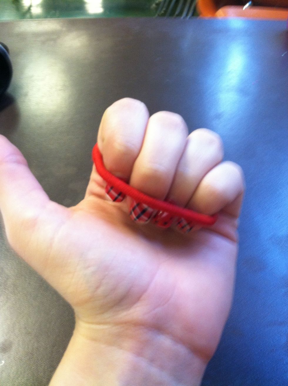 Then, keeping it on two fingers, pull it over all 4. This is what it will look like. Keep your hand closed. Don't let the person you're showing see this part.