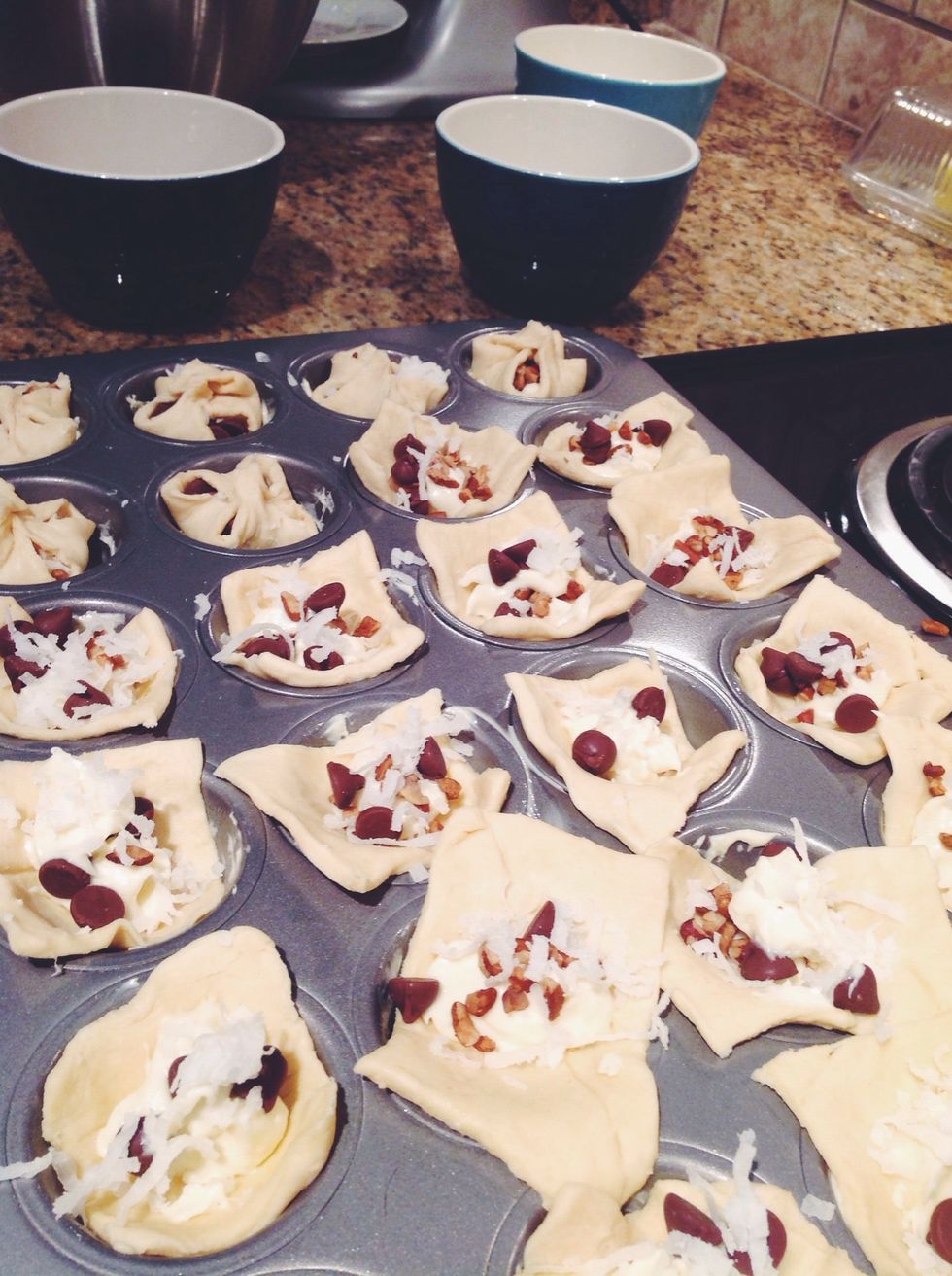 Then layer your pastry cuts with your cream cheese, then coconut, pecans, and chocolate chips. Have fun with it! 3 chips here, 5 pecans there... Don't fill them, leave room for sealing.