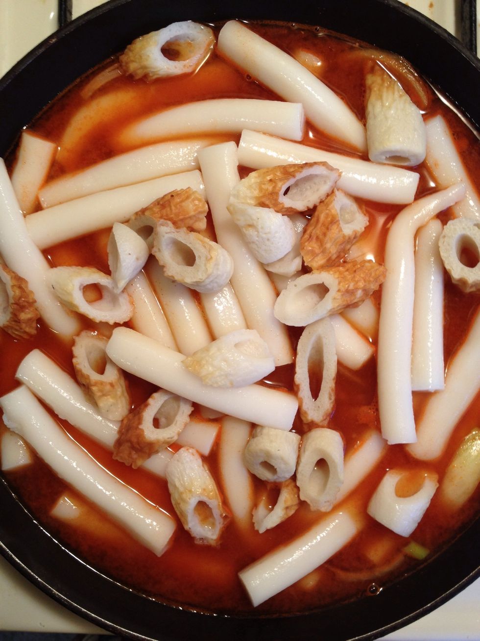 Then let's put all the ingredients in except the green scallion. Stir once in a while to prevent the rice cakes from sticking to the pan. Cook it for about 4-5 minutes in medium high heat