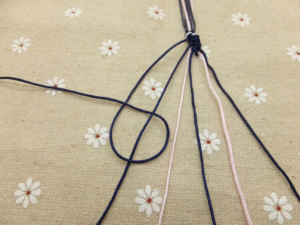 Then loop it under and back through the opening. Don\u2019t forget to knot twice over each cord!