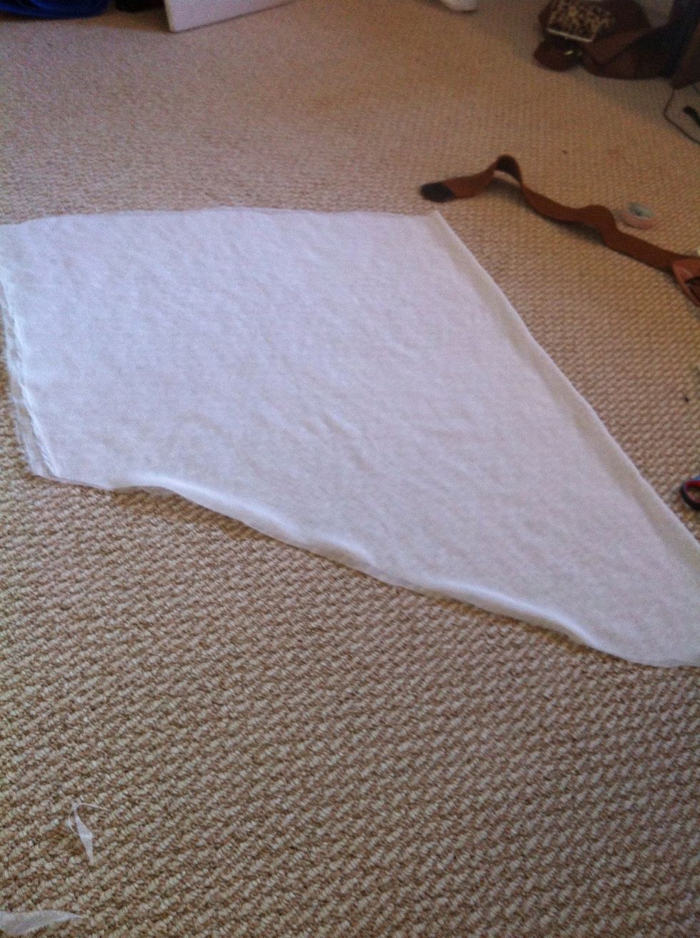Then on the longer side,fold the fabric in half n lay on floor,n cut it diagonally as shown in the picture. Sorry,It should be shorter and more diagonal (much shorter on left n a bit shorter on right)