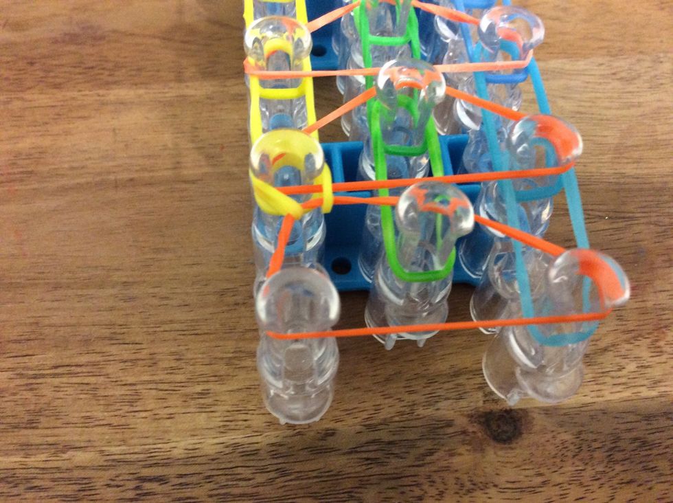 Then once you have the yellow loom in your hook carry it over and onto the peg in front as shown