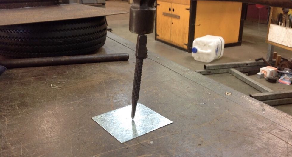 Then once you've found the center, use the center punch to create a dip in the metal for the pop rivet