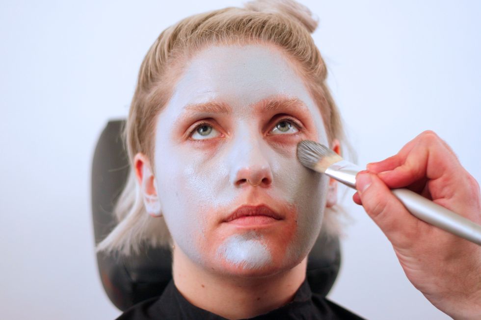 Then paint the entire face grey with a makeup brush. Work it up into the hairline, and get the neck, ears, and any other exposed skin.