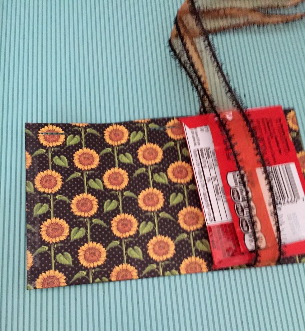 Then pass the ribbon around the candy and the ribbon through the grooves.. you need to make this once you close the cover with the double sided tape.