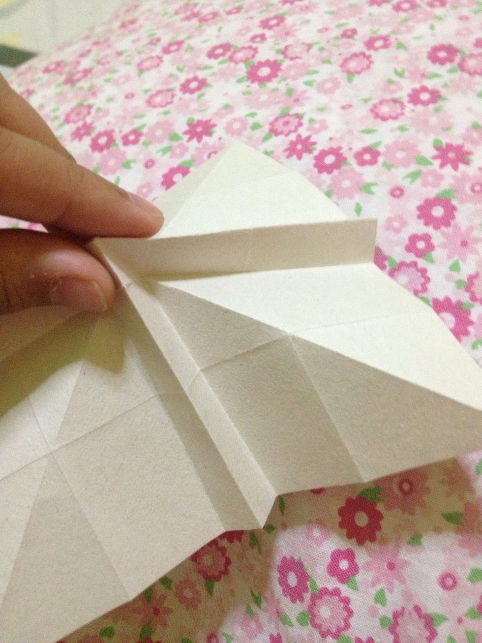 Then, pinch this tip and fold this corner. Do the same on the other side.