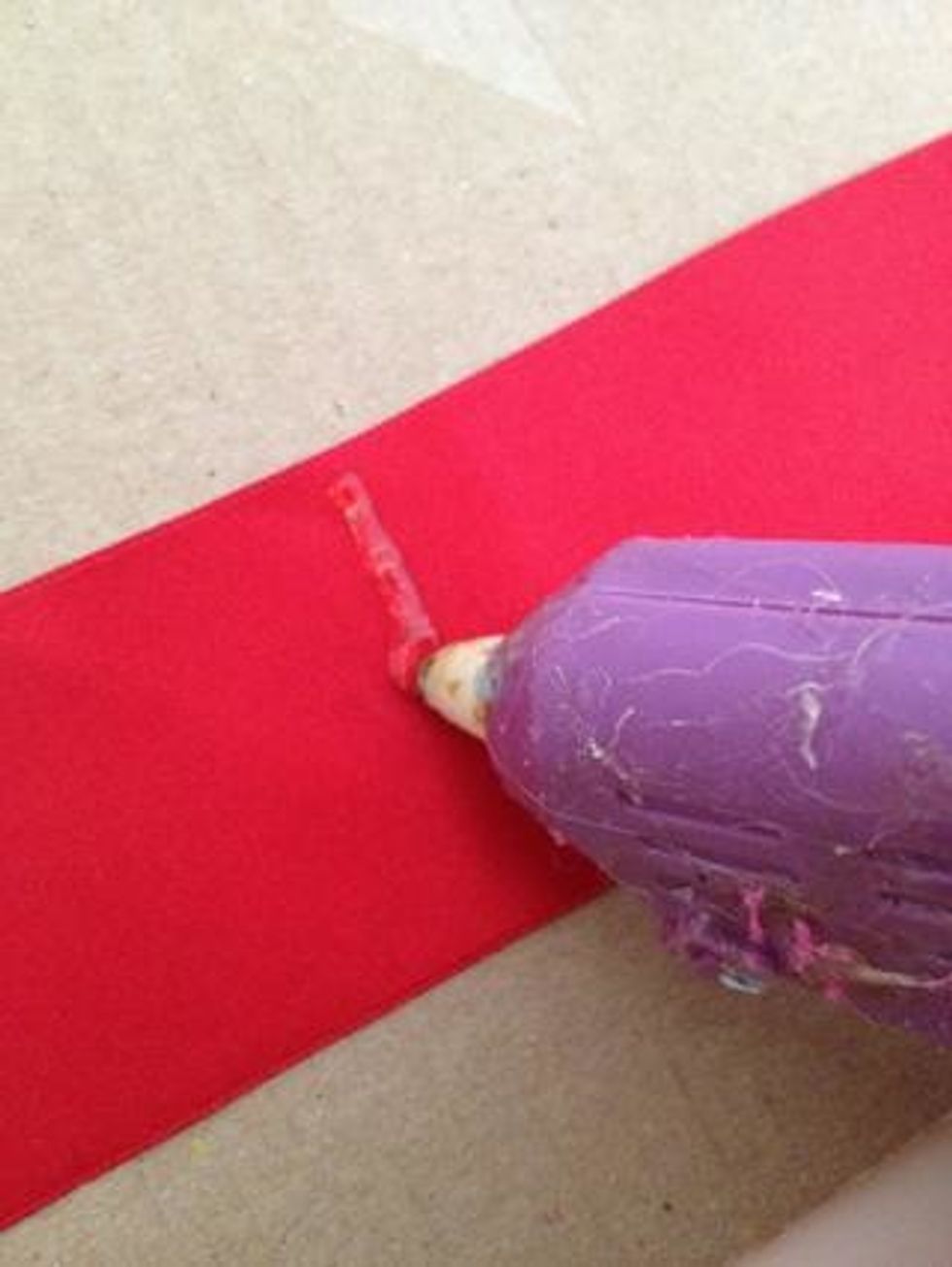 Then, Place a line of hot glue in the middle of the ribbon.