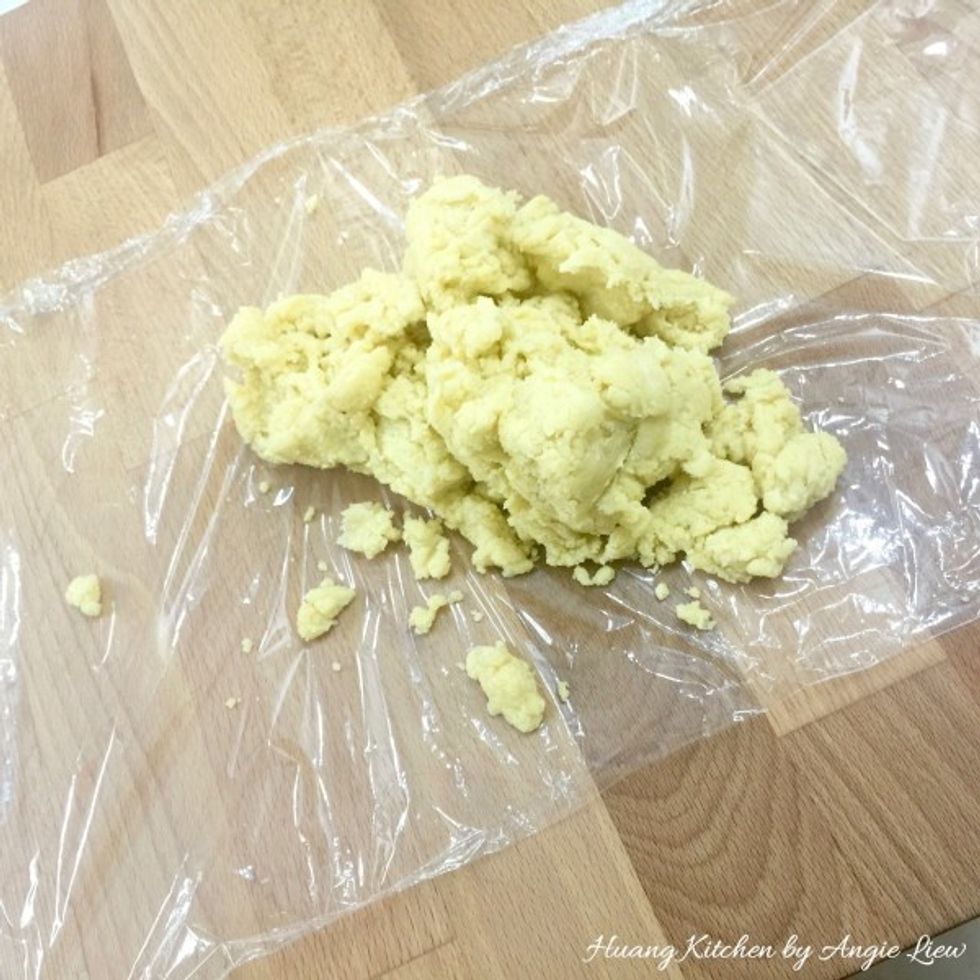 Then place a plastic wrap on the work surface. Turn the dough onto the top of the plastic wrap.