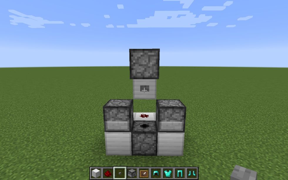 Then, place a stone button on the floating middle block so you can activate the Redstone dust and thus activate the dispensers.