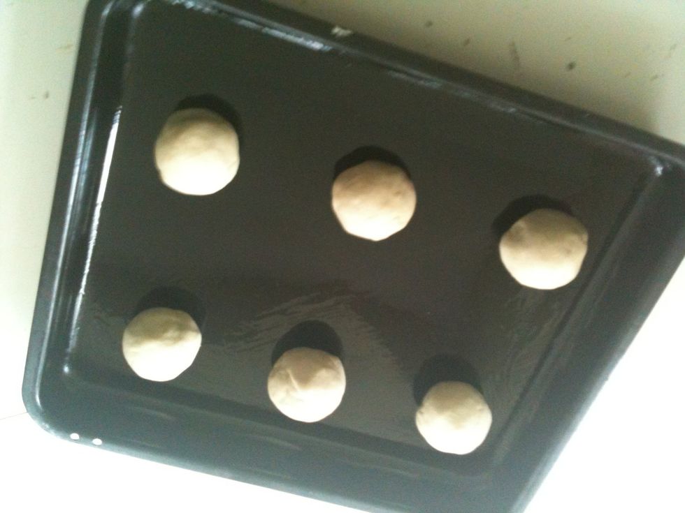 Then place the balls onto the baking tray, ready to go in the oven. Cling-film is optional for the next process. I normally top them with a little milk!