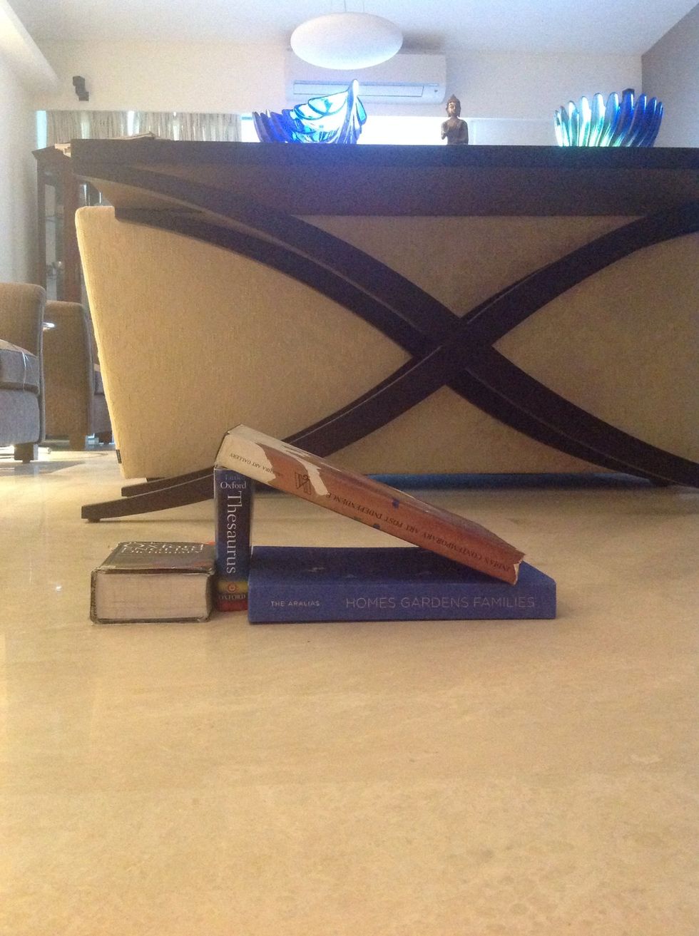 Then place the other thick book over the small strong book.