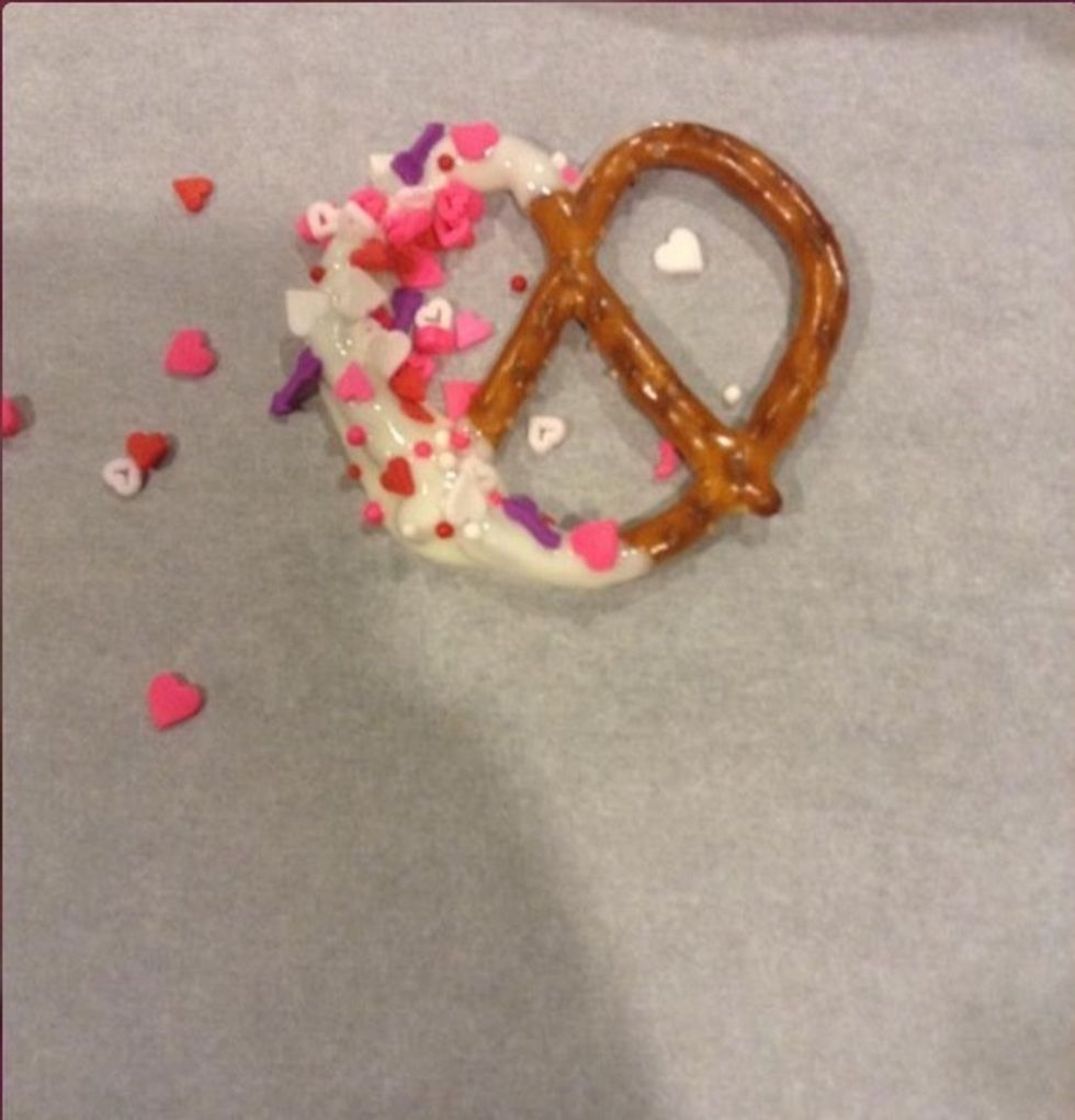 Then place the pretzels on the parchment paper, here you can add sprinkles if you want to, it makes them look 10x better!!
