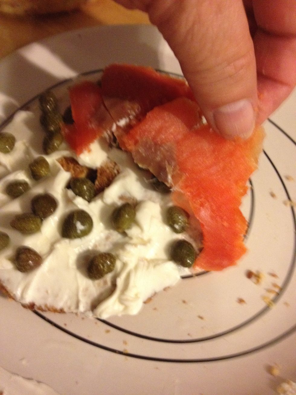 Then place the thin slices of smoked salmon on your bagel.