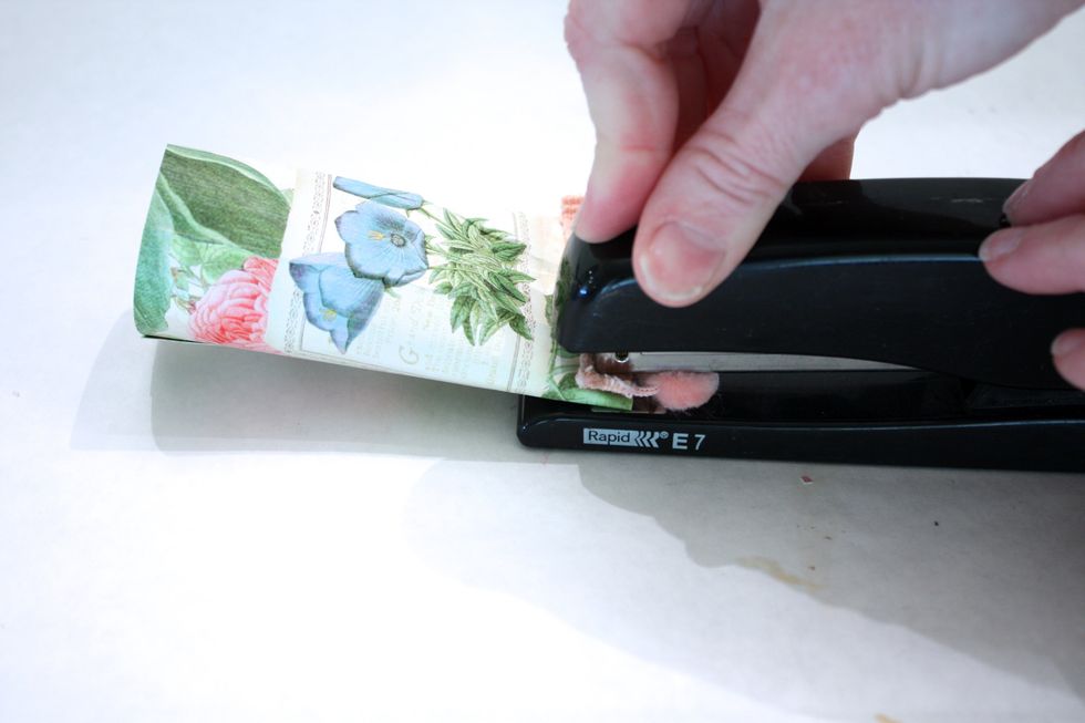 Then place three staples along the bottom. I added a little piece of pom pom trim too. TIP: use the stapler on a flat surface, it staples better