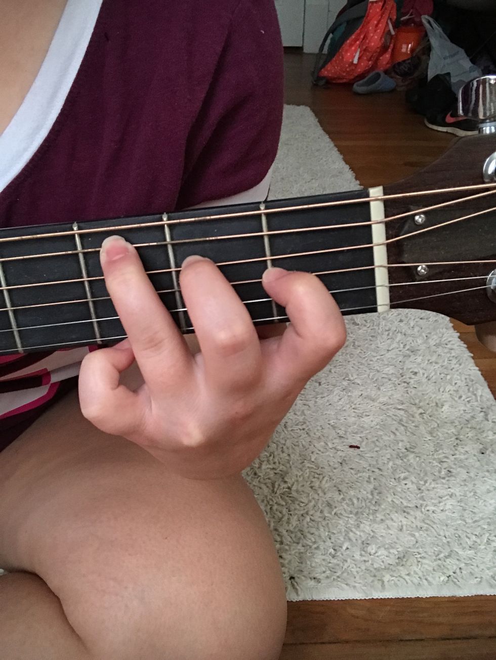 Then, place your pointer finger on the 2nd string, 1st fret. Your middle finger should go on the 4th string, 2nd fret. Your ring finger should go on the 5th string, 3rd fret. Press down. This is a C.