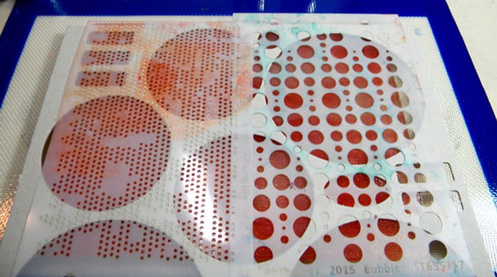 Then placed some smaller stencil circles on top of the chipboard and pressed them against the plate by rolling the brayer over the whole thing. Remove the stencils but leave the chipboard.