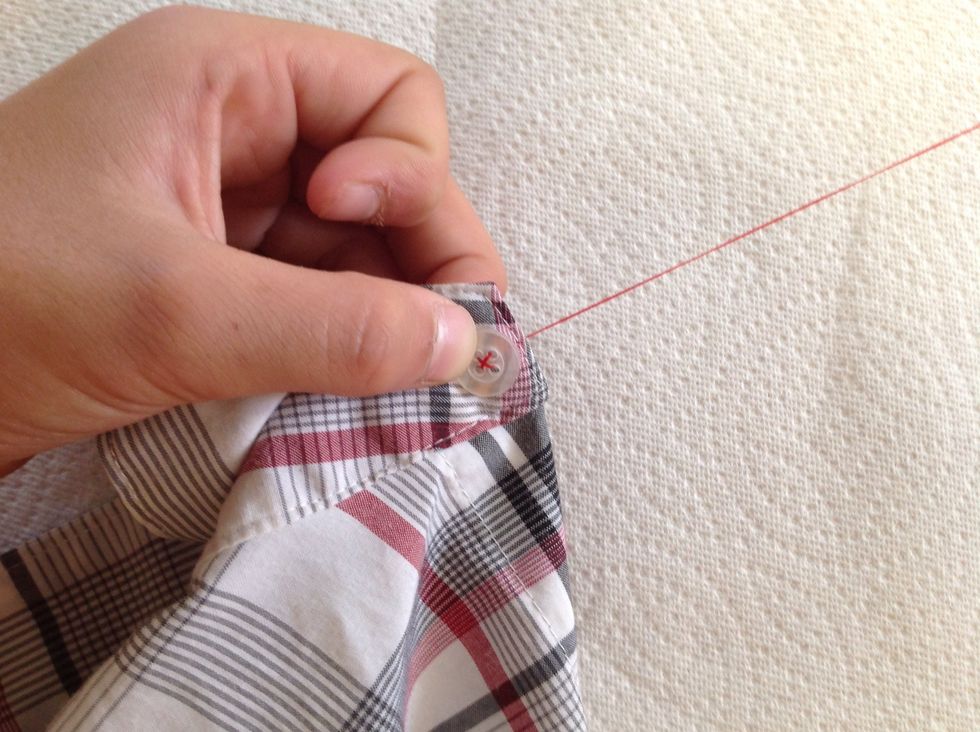Then, poke the needle and thread through the hole directly across, again making sure the thread is tight.  You now can have formed an "X" with your thread securely.