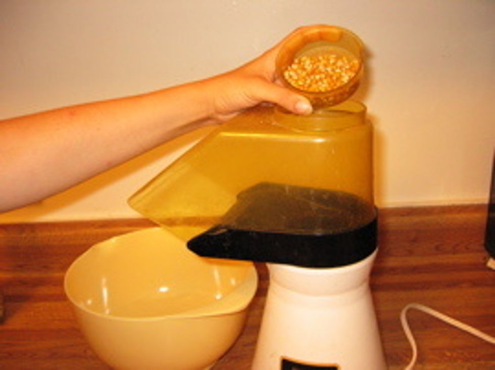 Then, pour the kernels into the air popper and turn it on.