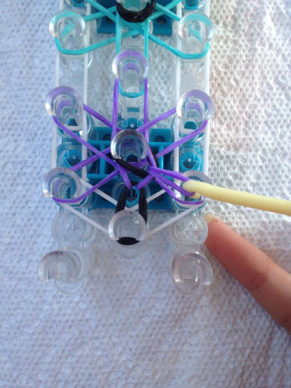 Then pull the next rubber band over the middle peg to the next peg counterclockwise. (it should be the same rubber band that was on the peg earlier). It just looks like a loop over the peg.